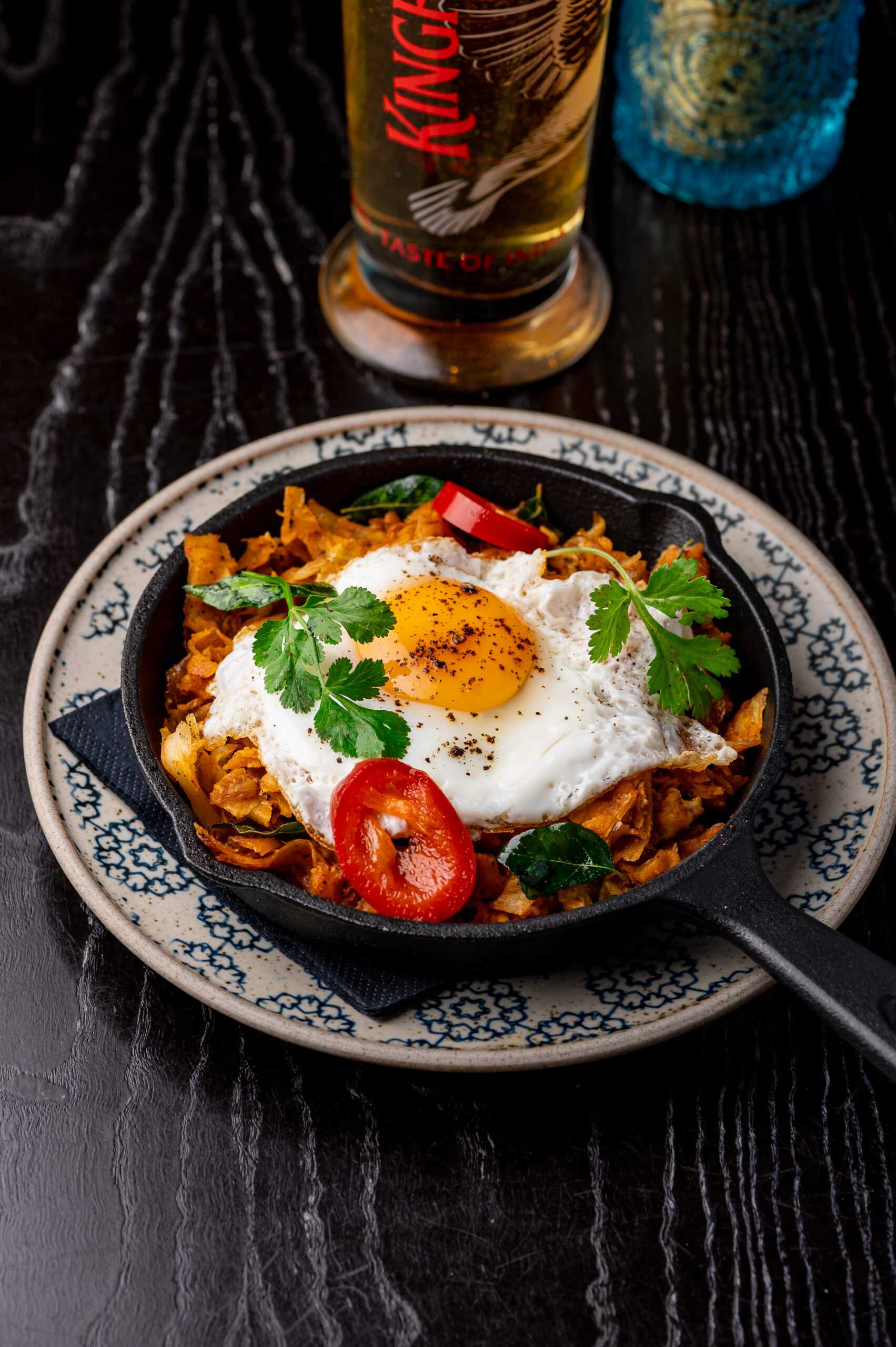 Chicken Kothu Porotta Leeds with fried egg and shredded flaky porotta on hot griddle